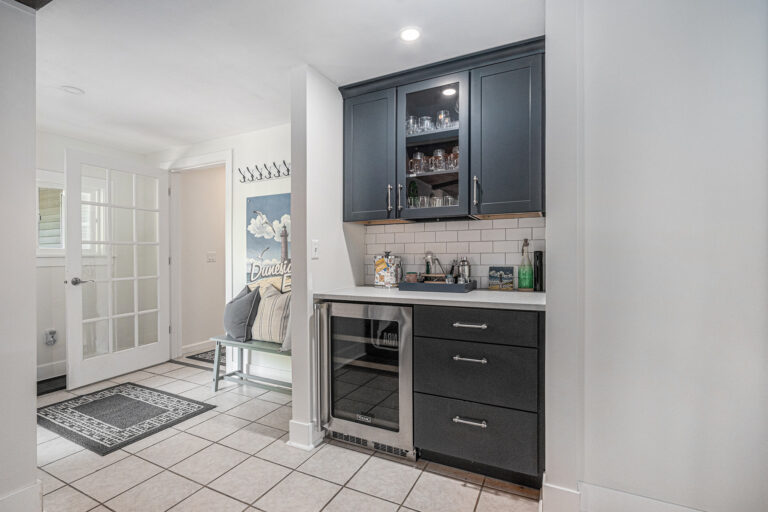 Modern kitchenette with dark cabinets and mini fridge