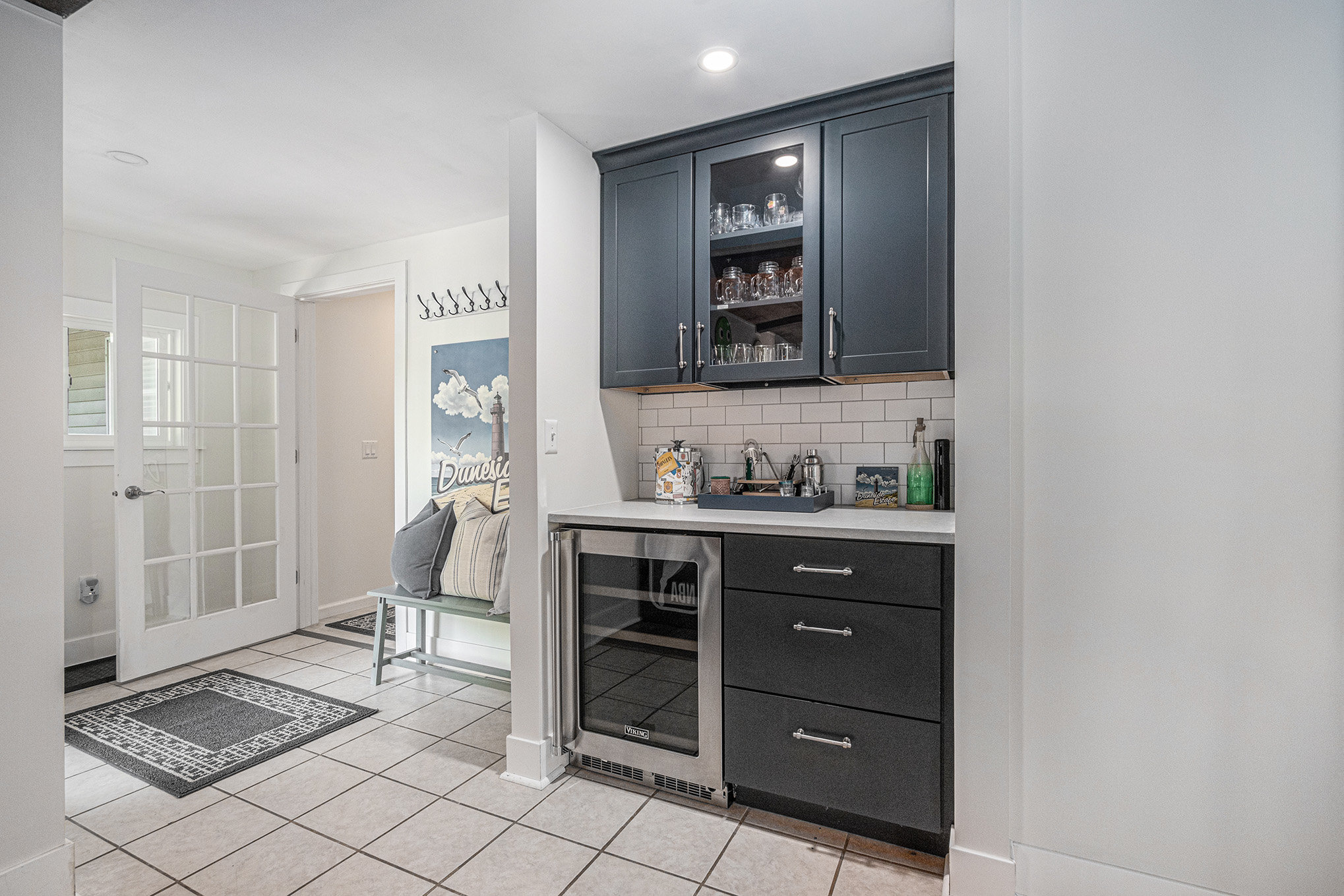 Modern kitchenette with dark cabinets and mini fridge