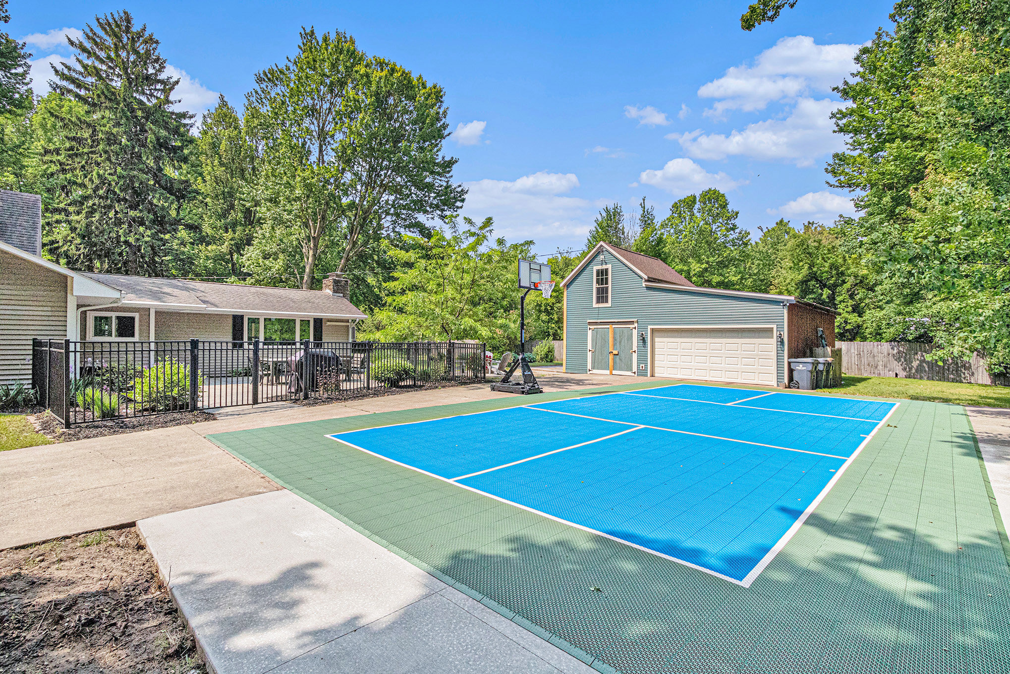 House with blue outdoor basketball court