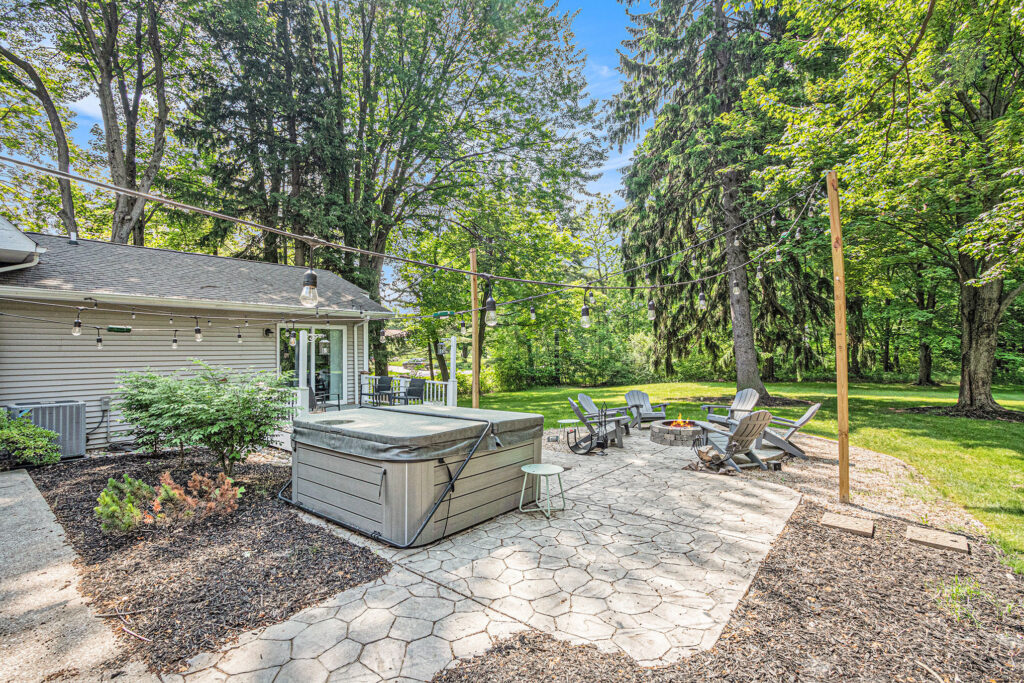 Backyard patio with hot tub and fire pit