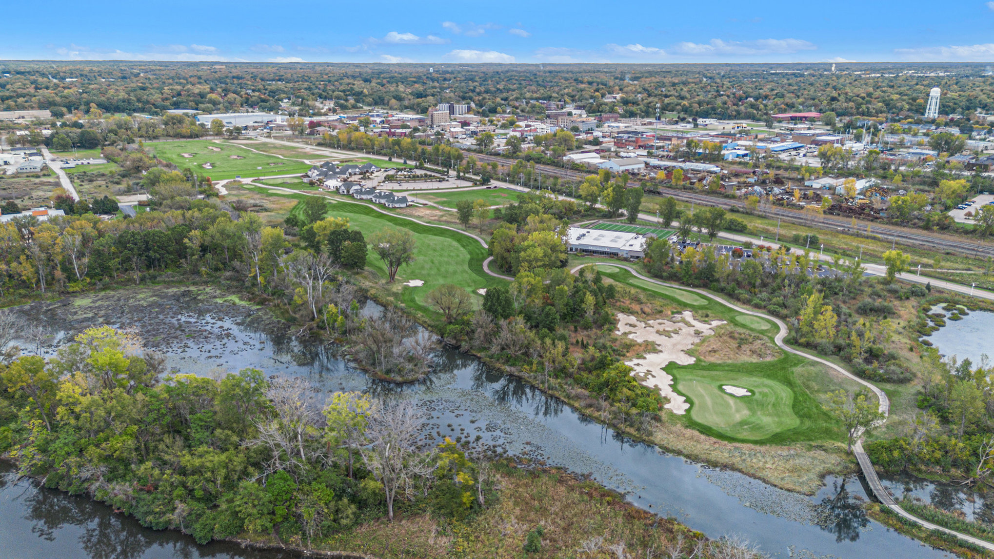 Aerial view of golf course near cityscape