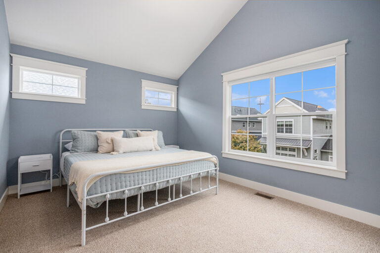 Bright bedroom with blue walls and large window
