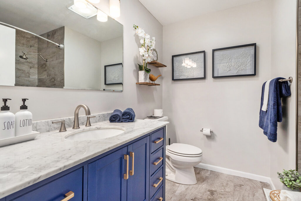 Modern bathroom with blue vanity and marble countertop