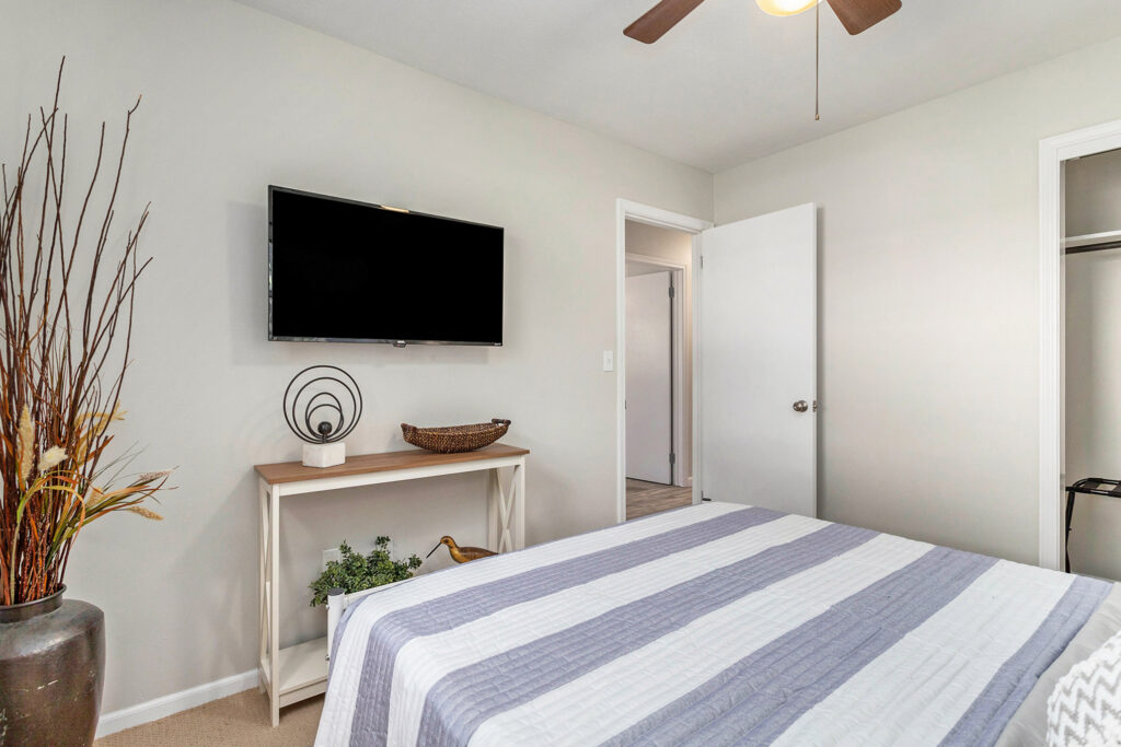 Modern bedroom with TV and striped bedding