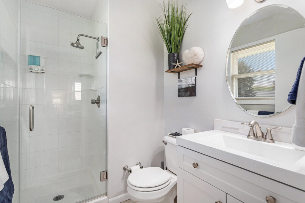 Modern bathroom with glass shower and white vanity.