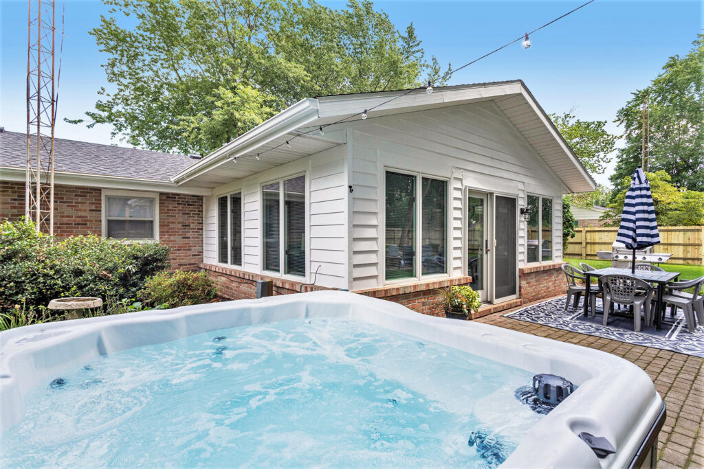 Backyard patio with hot tub and dining area