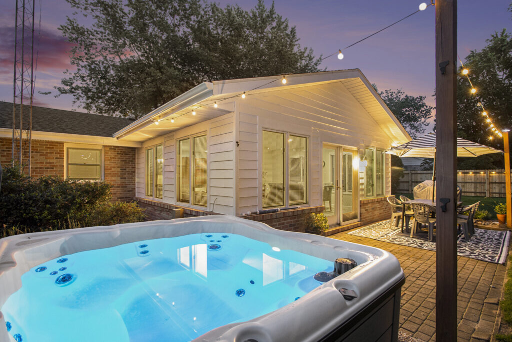 Backyard patio with hot tub and string lights