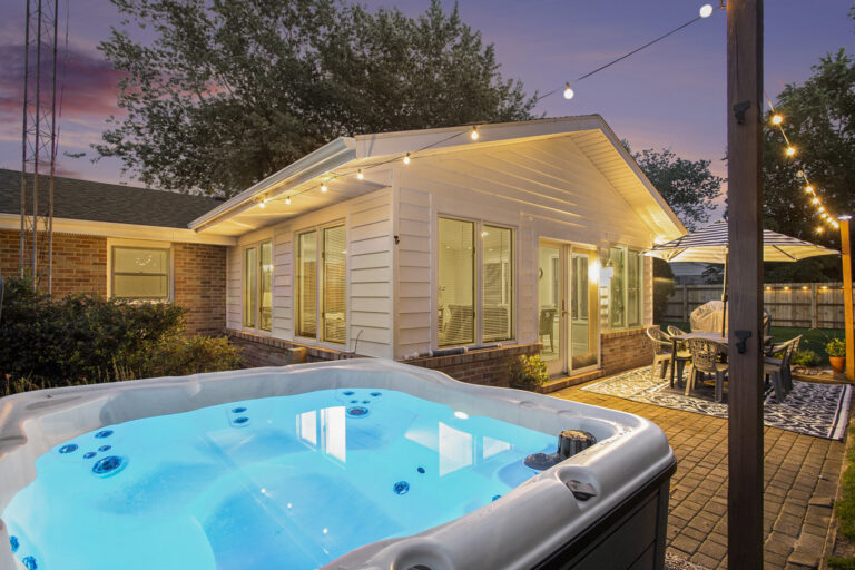 Backyard patio with hot tub and string lights
