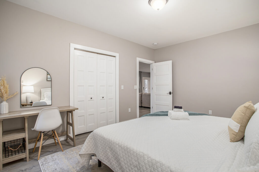 Modern bedroom with desk and white bedding