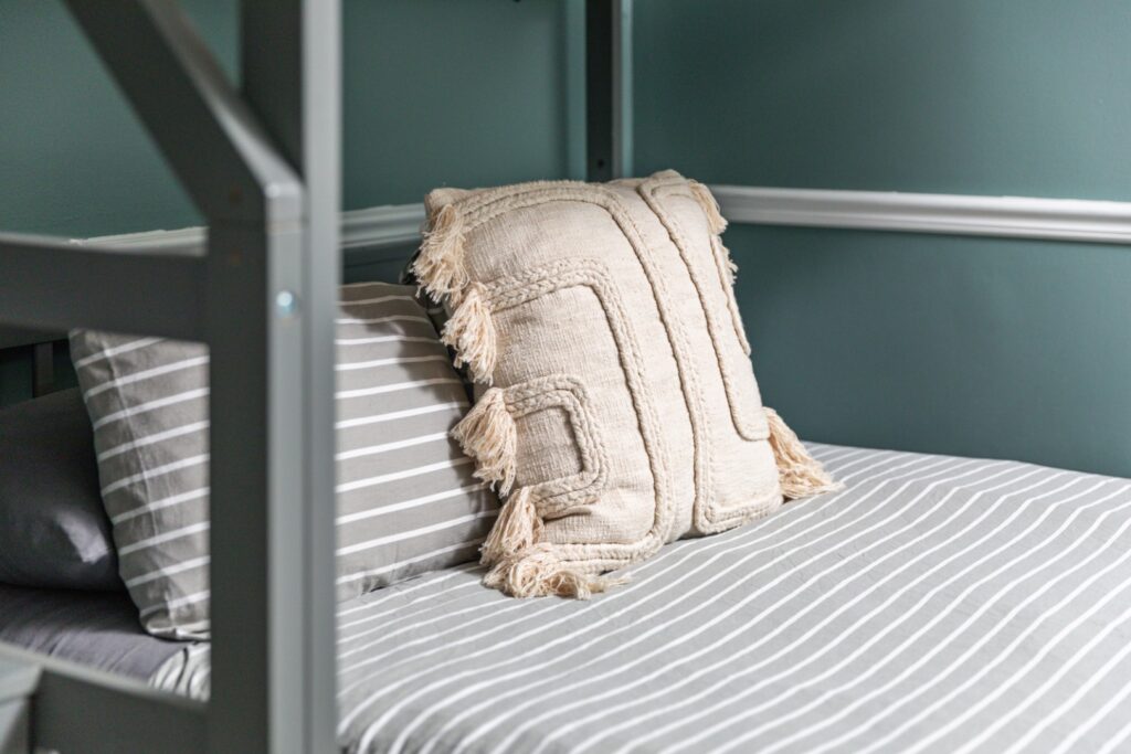 Striped bed with decorative beige pillow