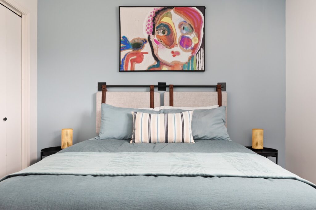 Modern bedroom with blue bedding and artwork