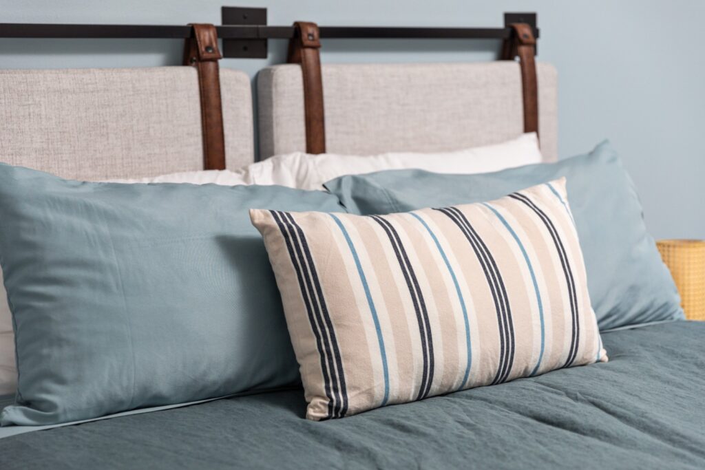Modern bed with blue and striped pillows