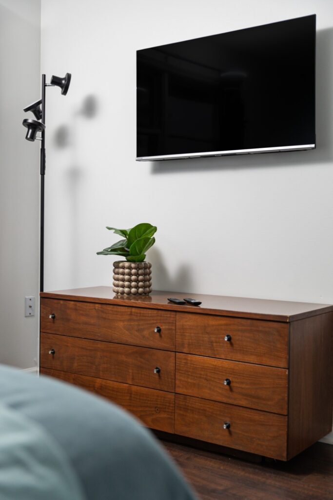 Modern bedroom with dresser and wall-mounted TV