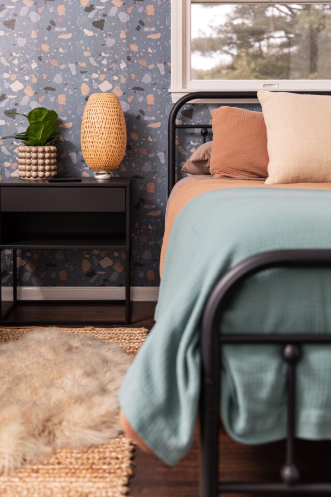 Modern bedroom with blue bedding and nightstand lamp