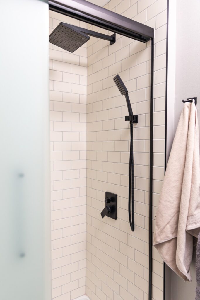 Modern shower with black fixtures and subway tiles