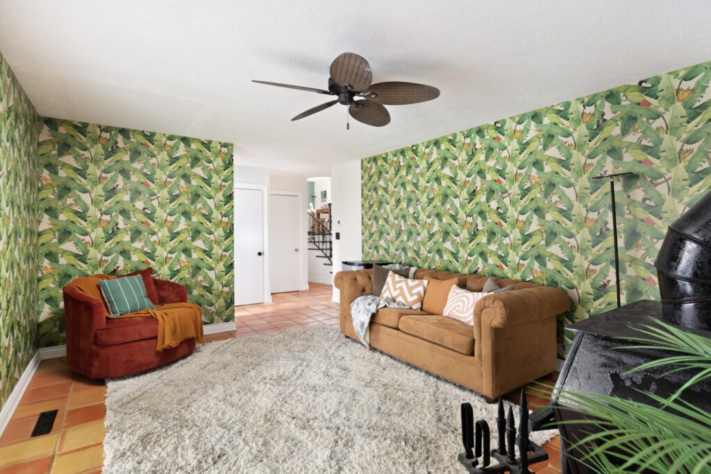 Tropical living room with leaf wallpaper and cozy seating