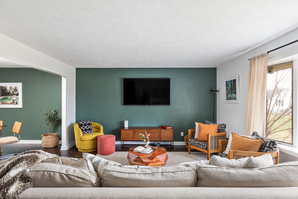 Modern living room with green accent wall and TV