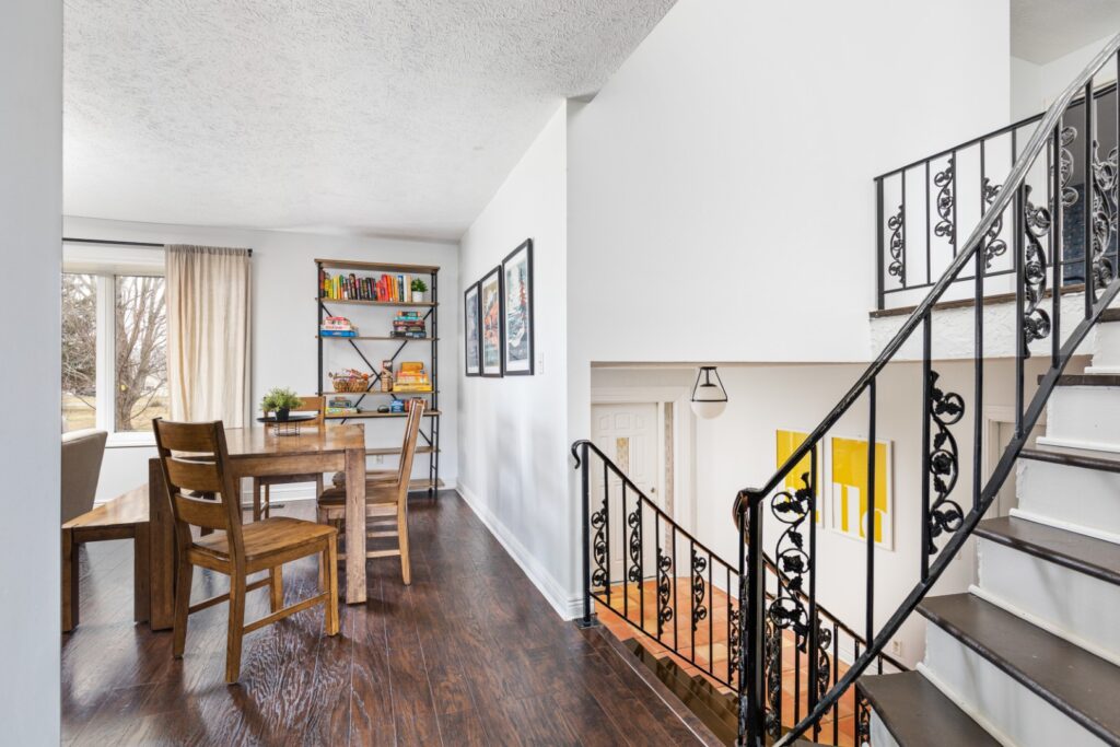 Bright dining area beside staircase with wooden furniture