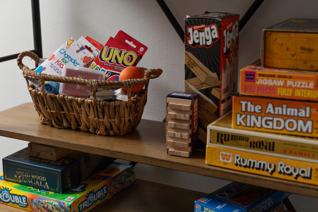 Stack of classic board and card games on shelf