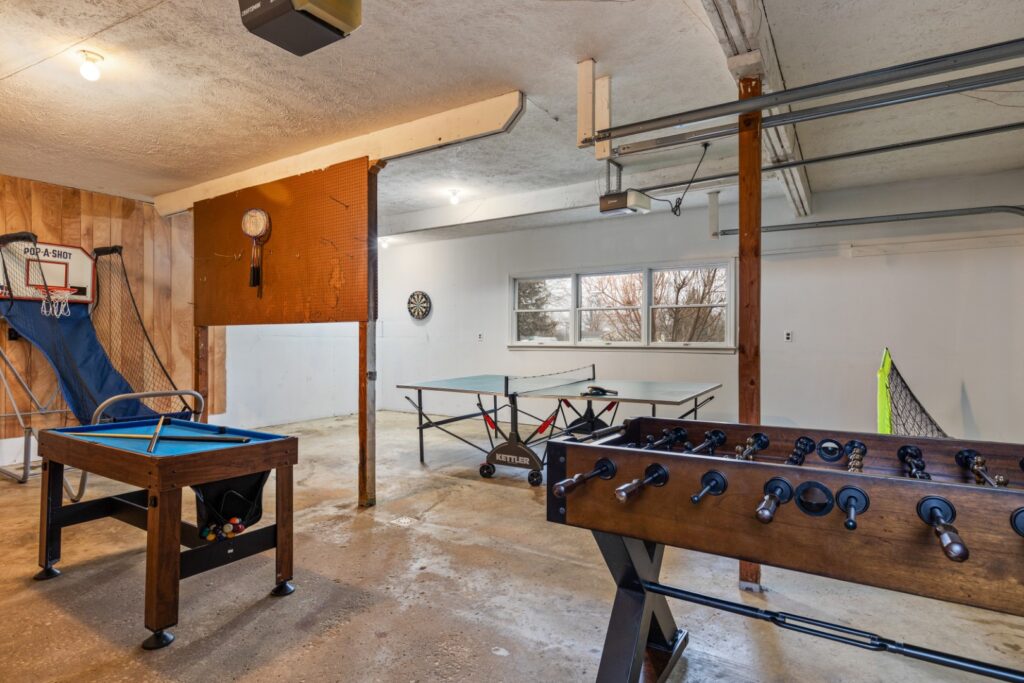 Basement game room with table games and basketball.