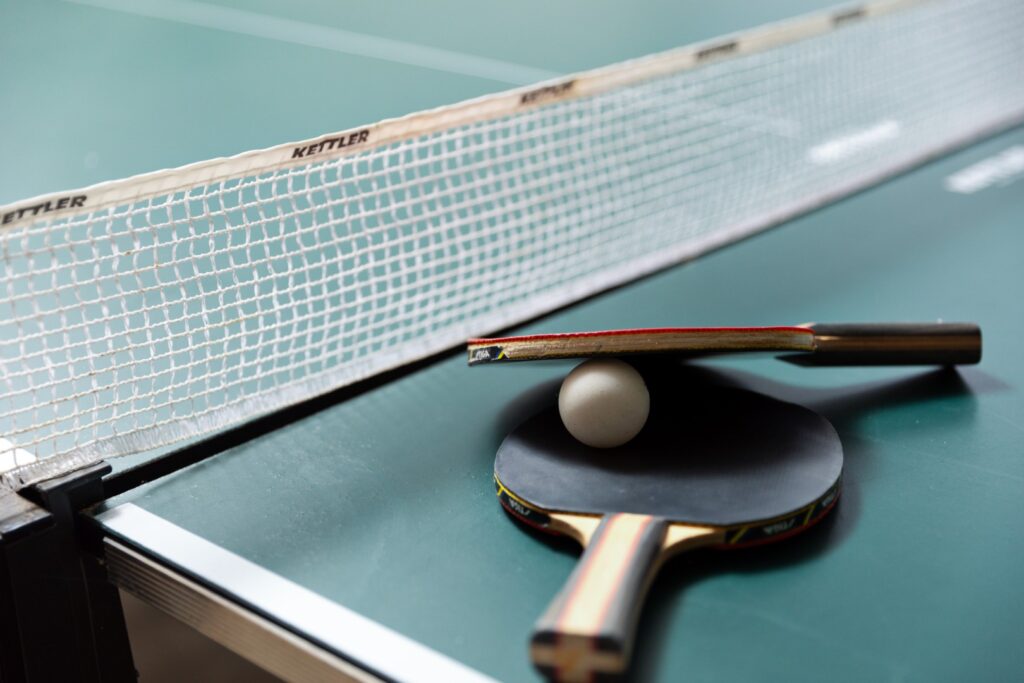 Table tennis paddles and ball on ping pong table