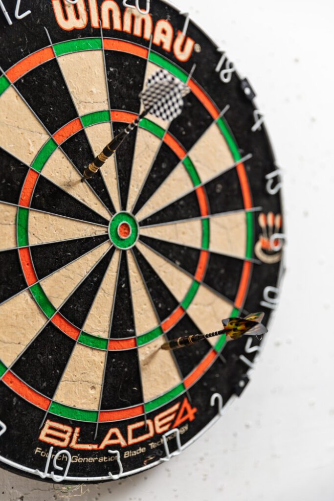 Dartboard with three darts stuck in it