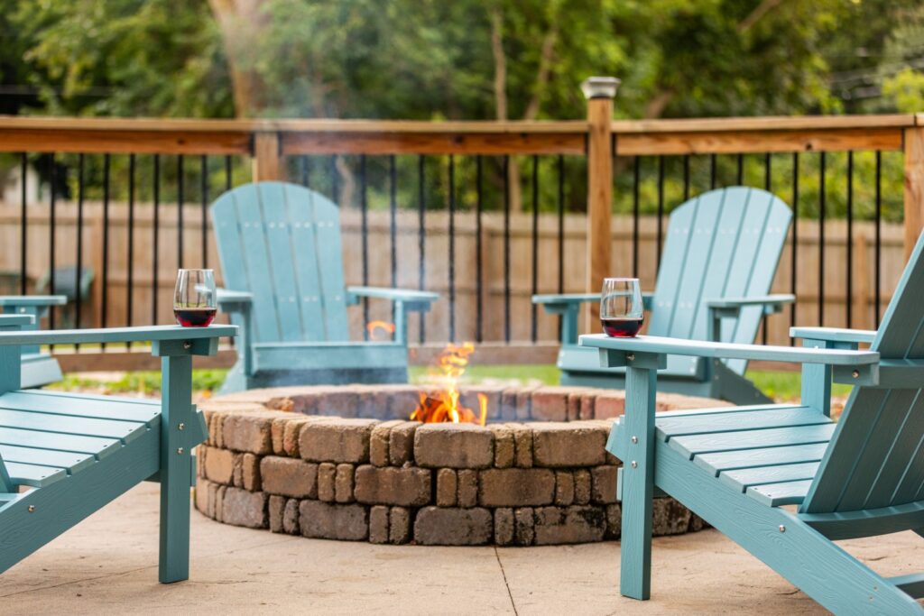 Outdoor fire pit with blue chairs and wine glasses
