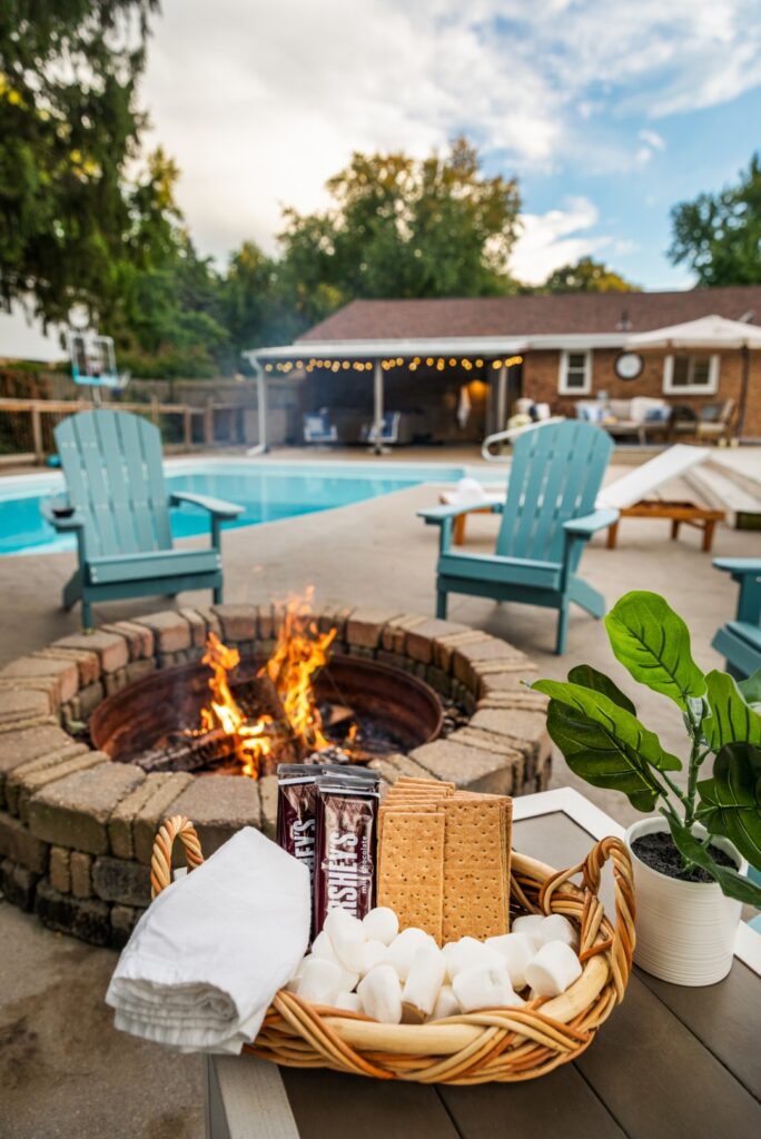 Backyard fire pit by pool with s'mores setup