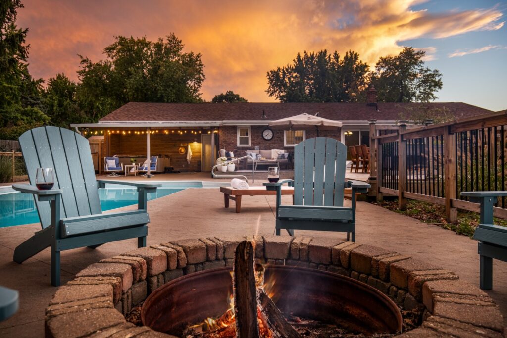 Backyard pool with fire pit at sunset