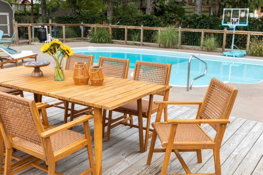 Wood patio table and chairs by pool
