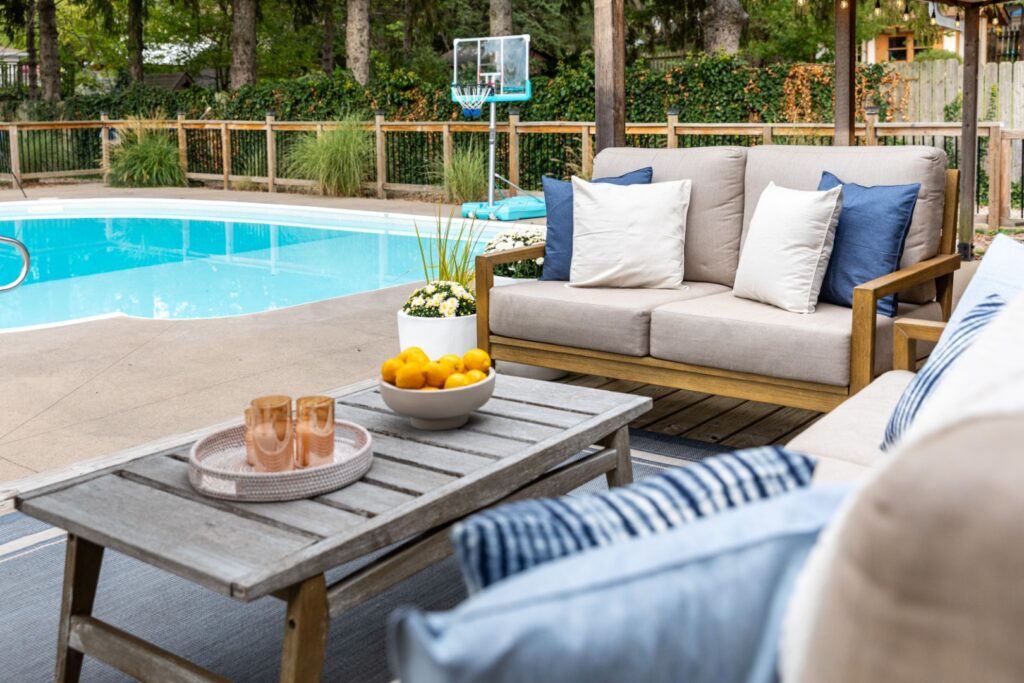 Outdoor patio seating beside a backyard swimming pool