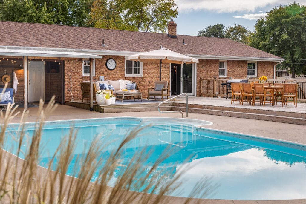 Brick house backyard with pool and patio furniture