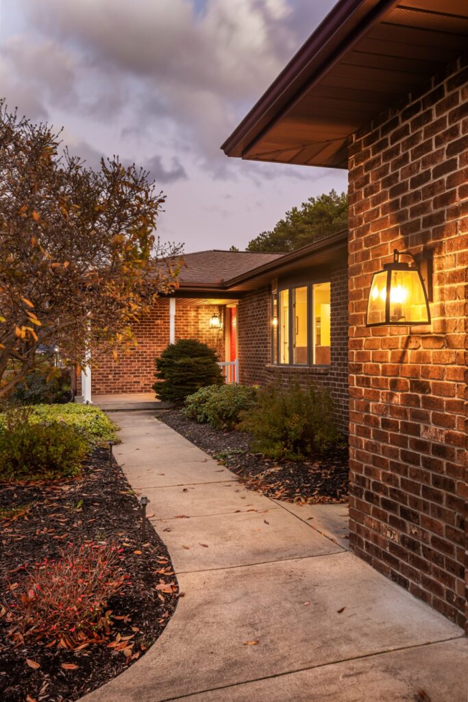 Brick house exterior with walkway at dusk