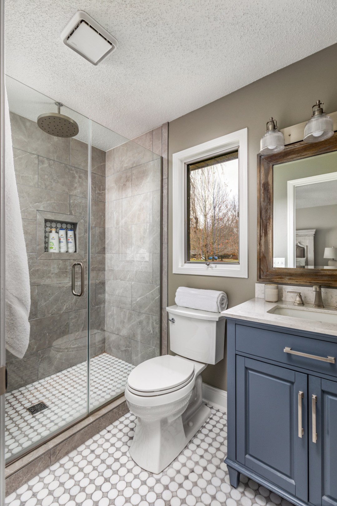 Modern bathroom with glass shower and blue vanity