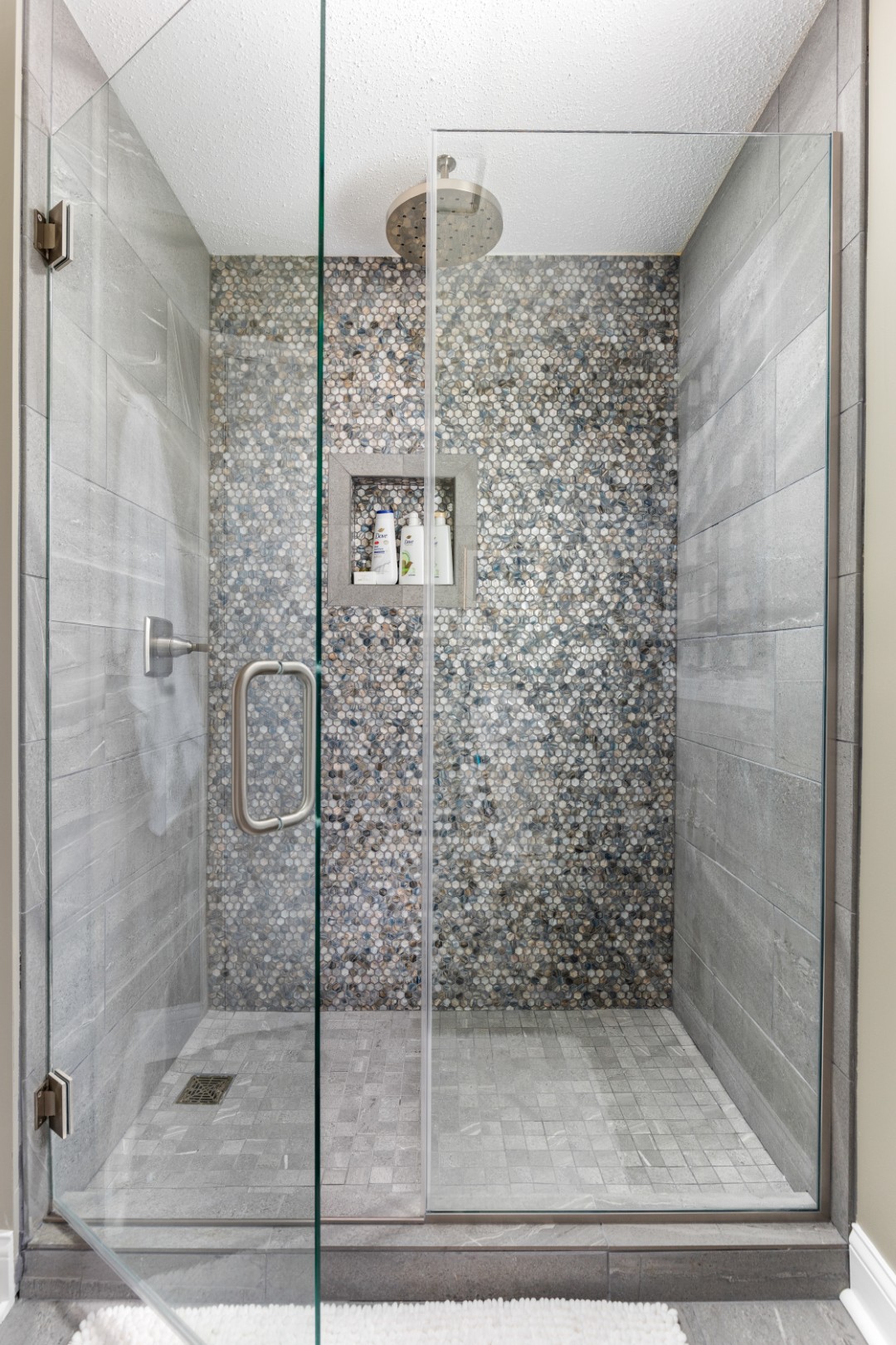 Modern glass shower with mosaic tile wall