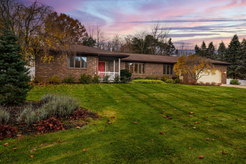 Brick house with large lawn at sunset