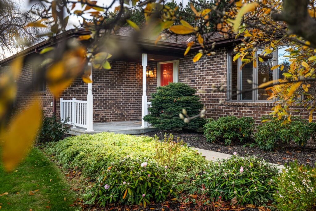 Brick house with red door and green garden