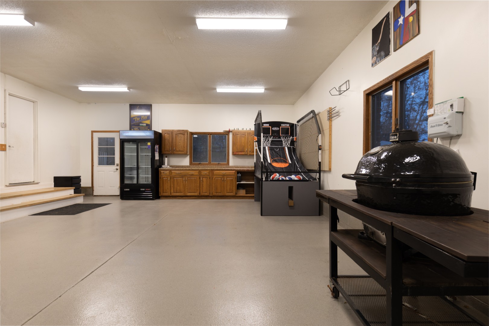 Clean garage with basketball game and grill