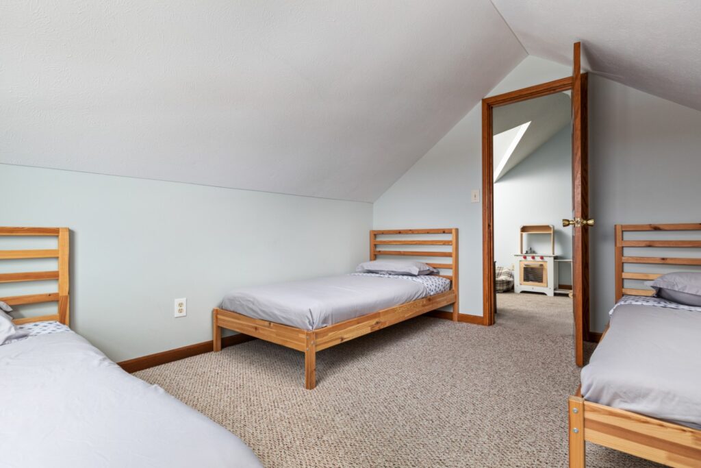 Attic bedroom with three single wooden beds