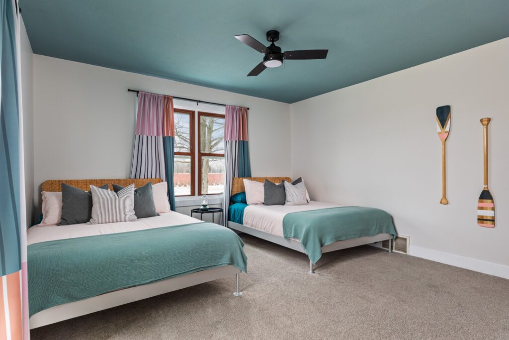 Modern bedroom with two beds and teal ceiling