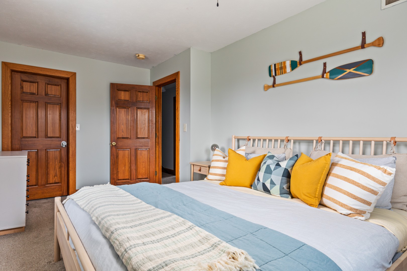 Cozy bedroom with colorful pillows and wooden doors