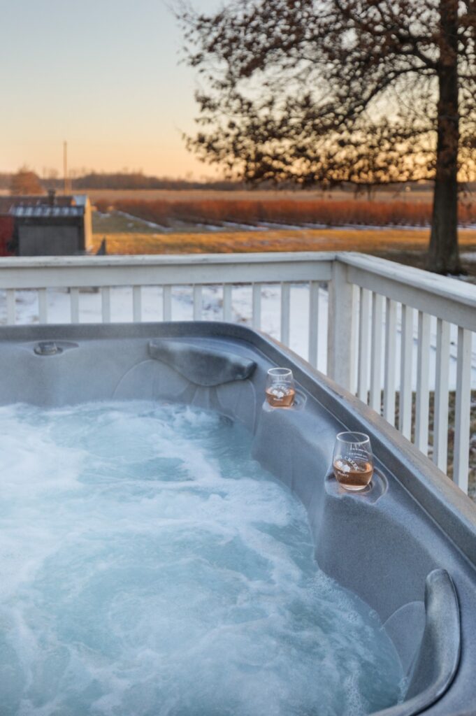 Hot tub with drinks overlooking sunset field