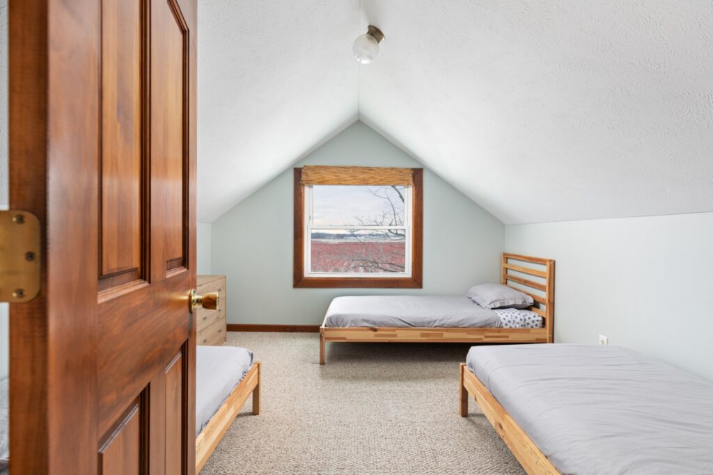 Cozy attic bedroom with twin beds and window view