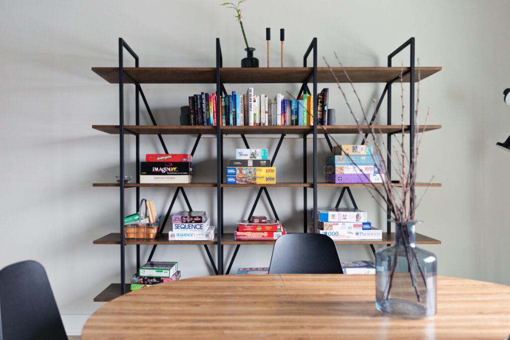 Bookshelf with books and board games in modern room