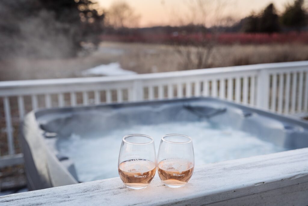 Two wine glasses beside outdoor hot tub
