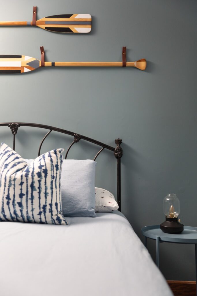 Cozy bedroom with blue decor and oar wall art