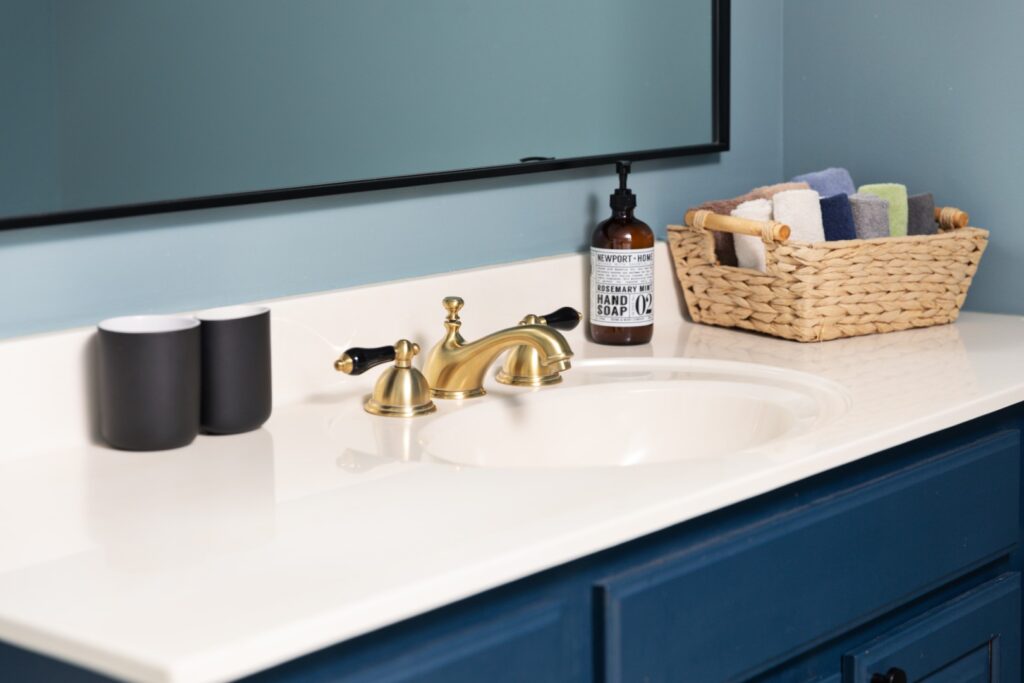 Modern bathroom sink with gold faucet and basket