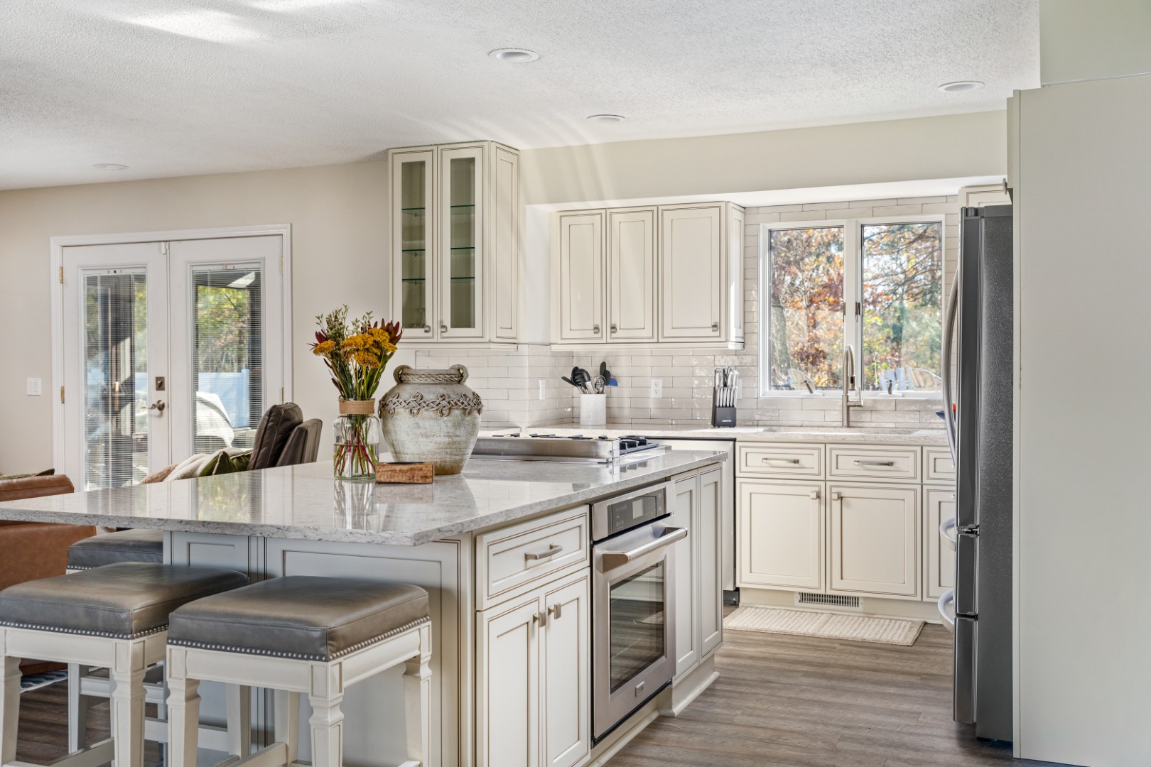 Modern white kitchen with marble island and stools