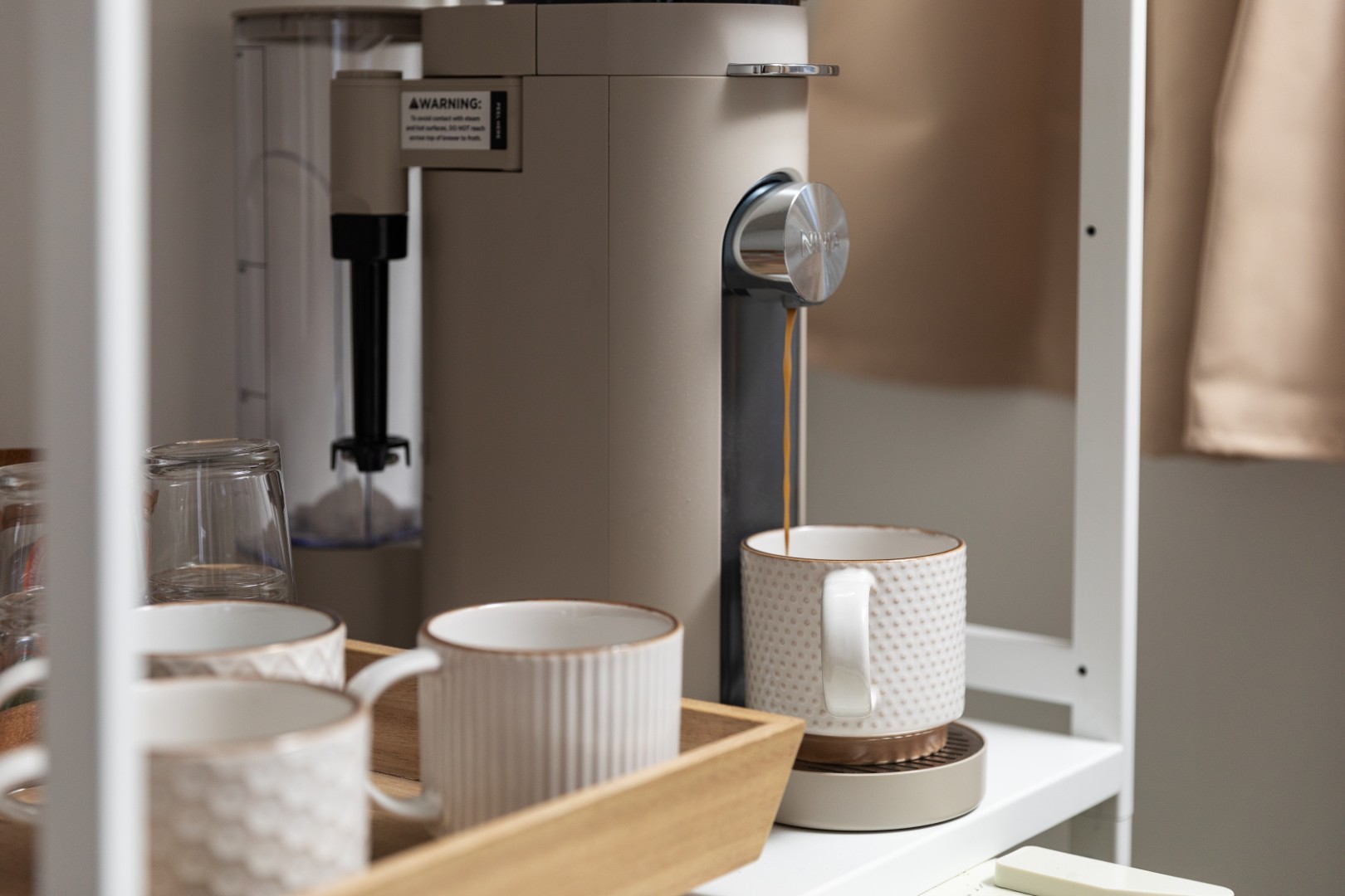 Coffee machine brewing coffee into ceramic mug