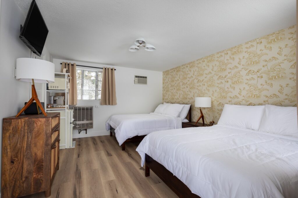 Modern hotel room with two beds and wooden furniture